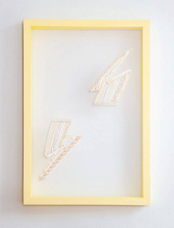 Two lighting symbols opposite one another diagonally on transparent mesh. The embroidered work is framed with a yellow wood frame.