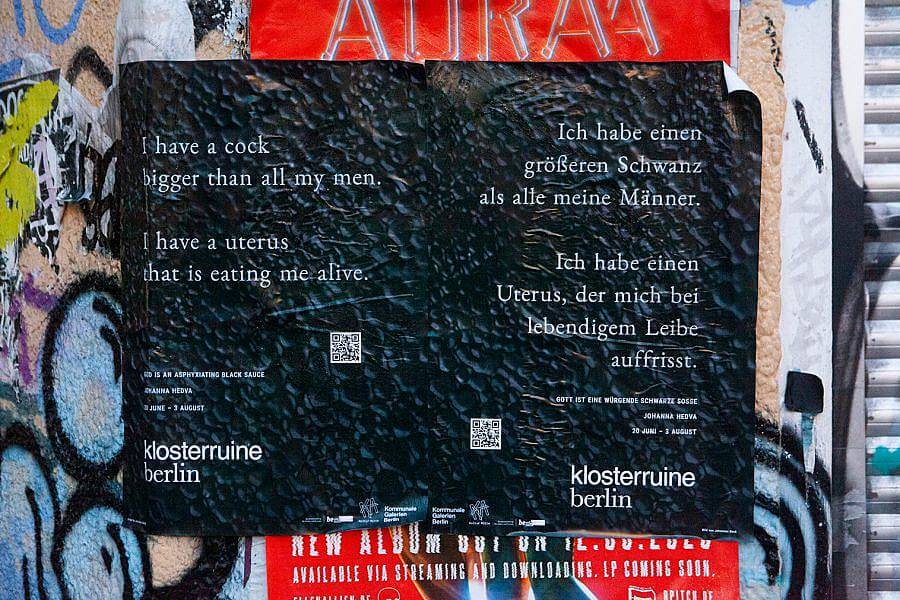 Image description: A Black shiny sheet is on top of other posters. A poem on the left reads " I have cock bigger than all my men. I have a uterus that is eating me alive." The poem is repeated on the right in German. 