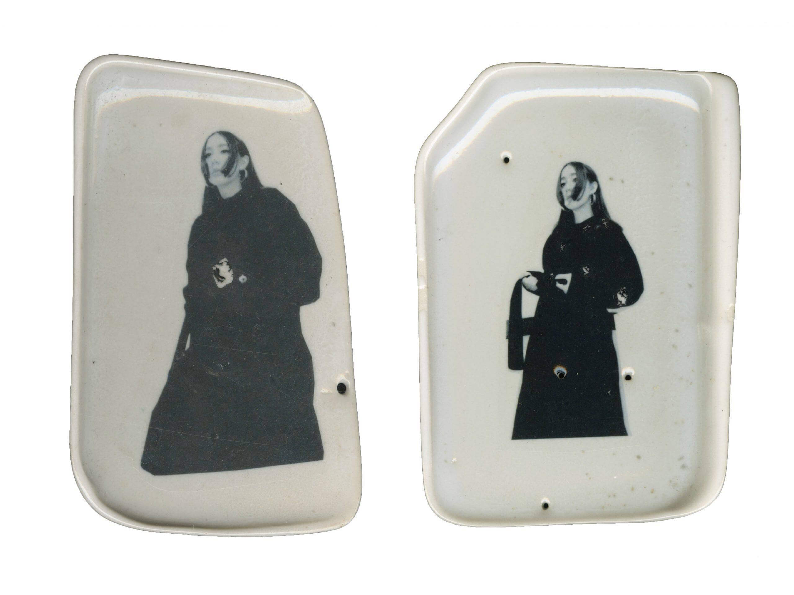 two white ceramic objects with decals of the artist
