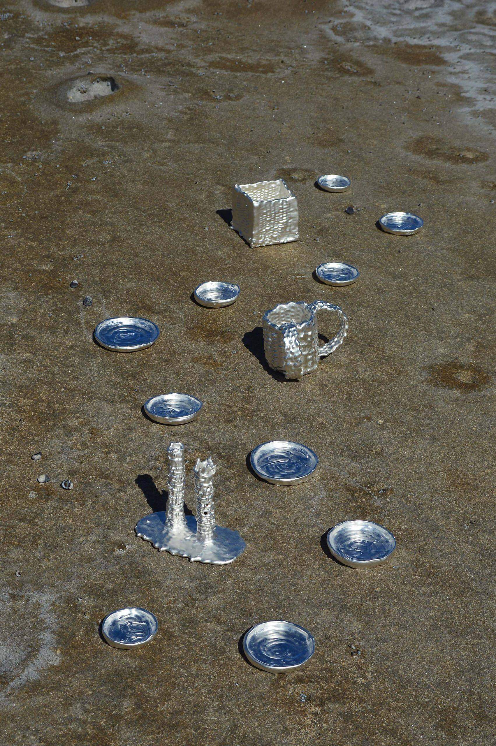 silver Judaica objects sitting on sand